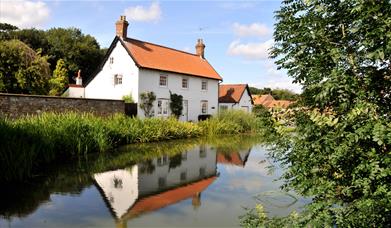 A cottage overlooking a river running through Bishop Burton, in East Yorkshire